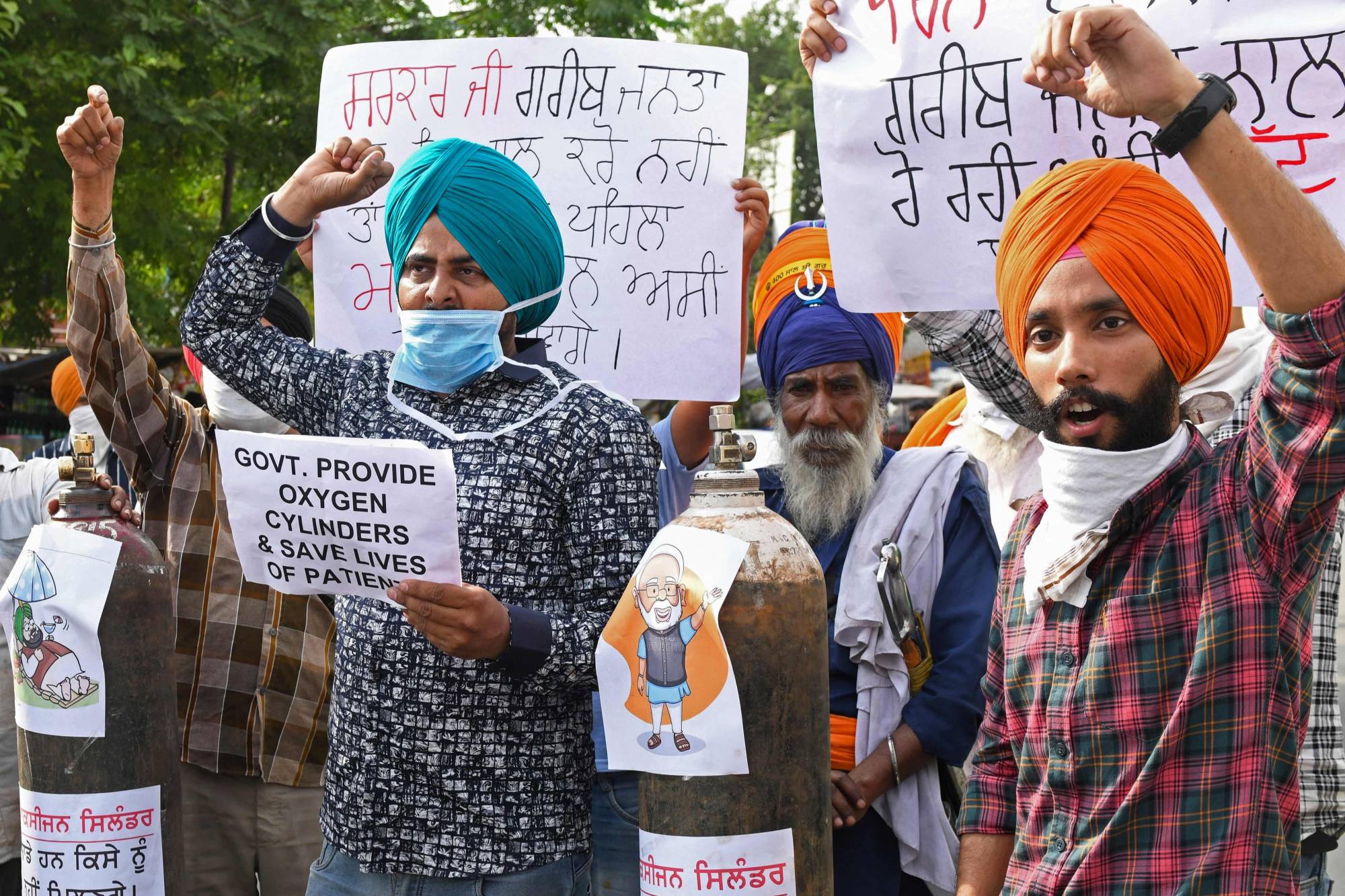 Demonstrators hold oxygen cylinders as they shout slogans protesting Indian lawmakers during a rally in Amritsar on Friday. | AFP-JIJI