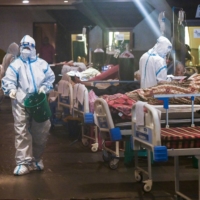 Health workers attend to patients inside a banquet hall temporarily converted into a COVID-19 ward in New Delhi on Saturday.  | AFP-JIJI