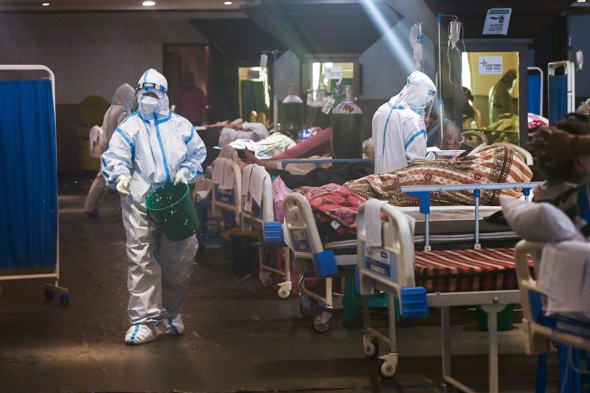 Health workers attend to patients inside a banquet hall temporarily converted into a COVID-19 ward in New Delhi on Saturday.  | AFP-JIJI