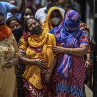 Relatives of COVID-19 victims mourn outside a hospital mortuary in Delhi on April 23.  | ATUL LOKE / THE NEW YORK TIMES


