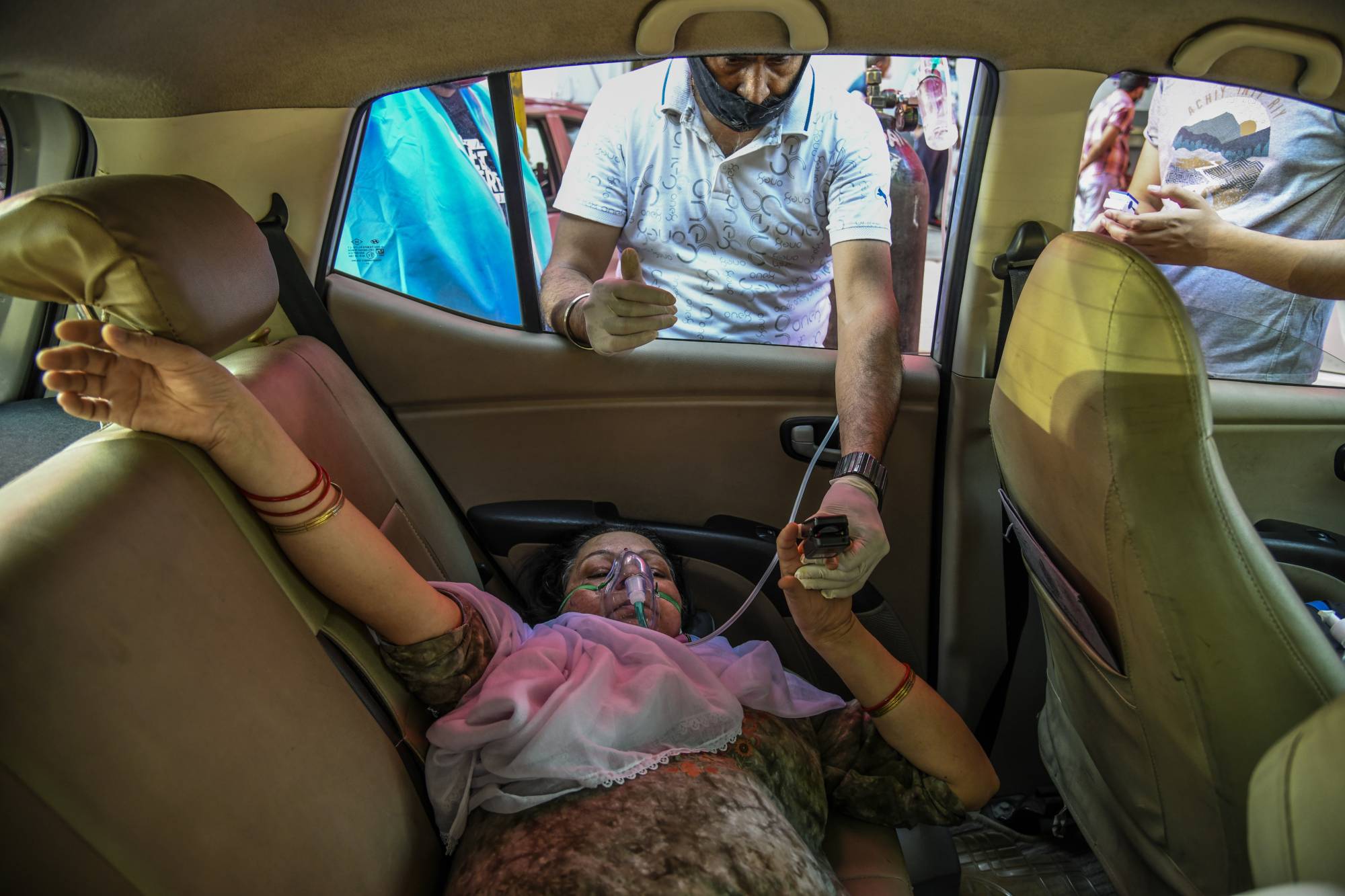 A woman with COVID-19 receives oxygen in Delhi on April 25.  | ATUL LOKE / THE NEW YORK TIMES