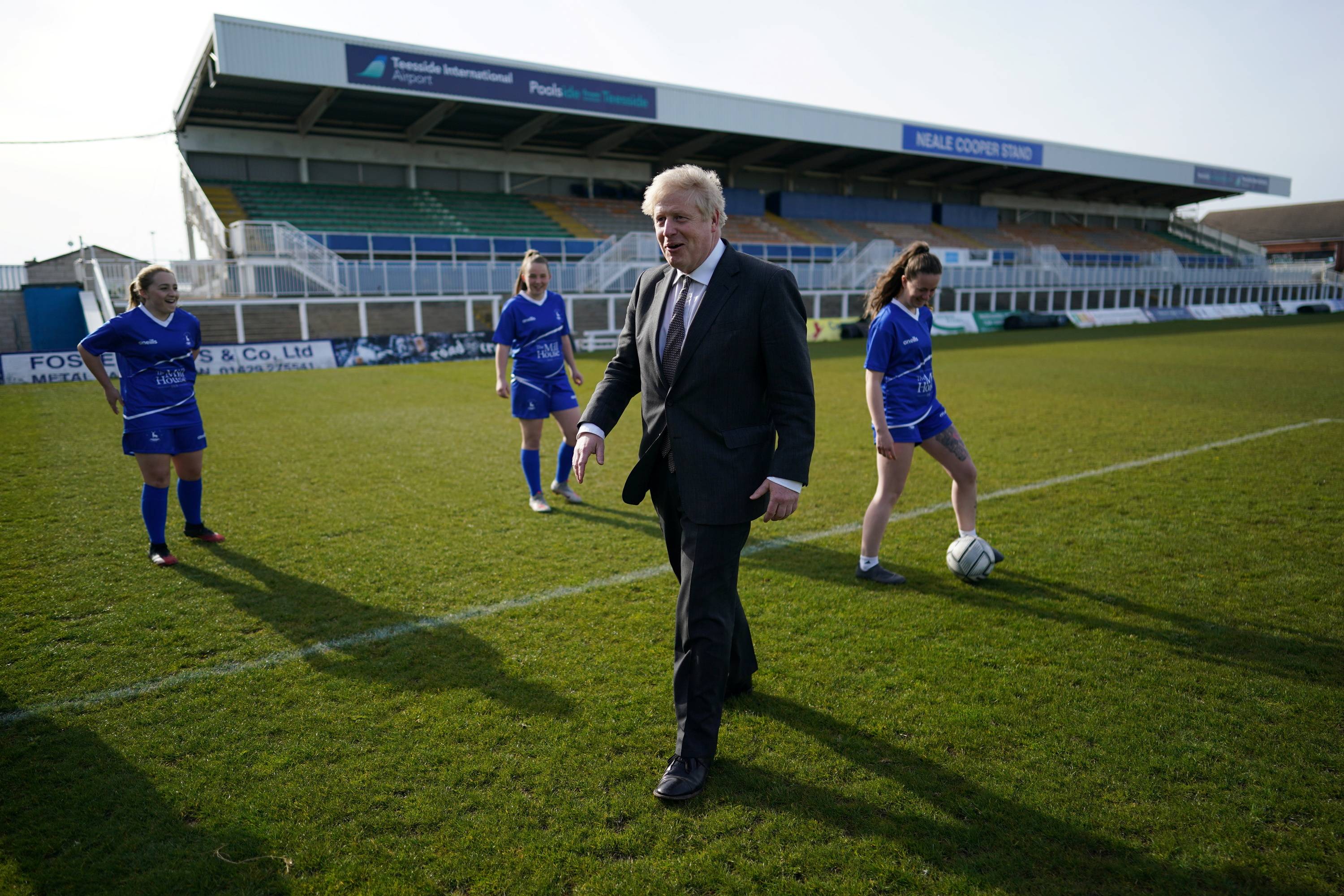 British Prime Minister Boris Johnson speaks with members of the Hartlepool United Ladies Team during a visit in Hartlepool, England, on April 23. | Pool / via REUTERS