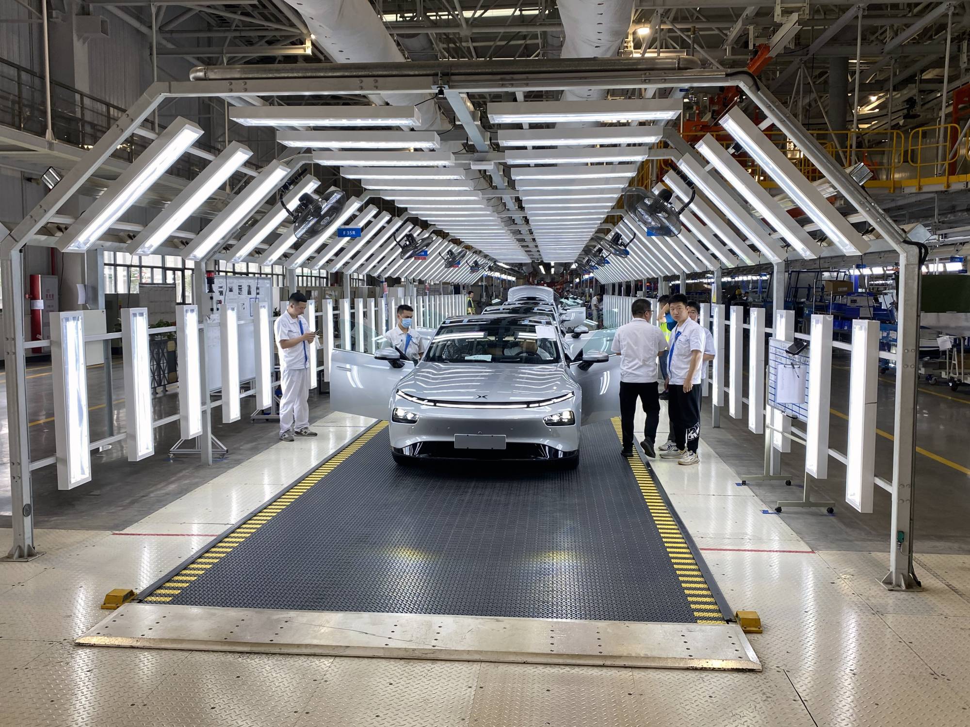 An electric car nears the end of the assembly line at Xpeng’s factory in Zhaoqing, China. China will be making over 8 million electric cars a year by 2028, estimates LMC Automotive, a global data firm, compared with 1 million last year. Europe is on track to make 5.7 million fully electric cars by then. | KEITH BRADSHER / THE NEW YORK TIMES
