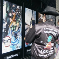 A poster for the \"Demon Slayer\" film is put up in Tokyo on its opening day on Oct. 16, 2020. The film grabbed the top spot in last weekend\'s U.S. box office revenues. | KYODO

