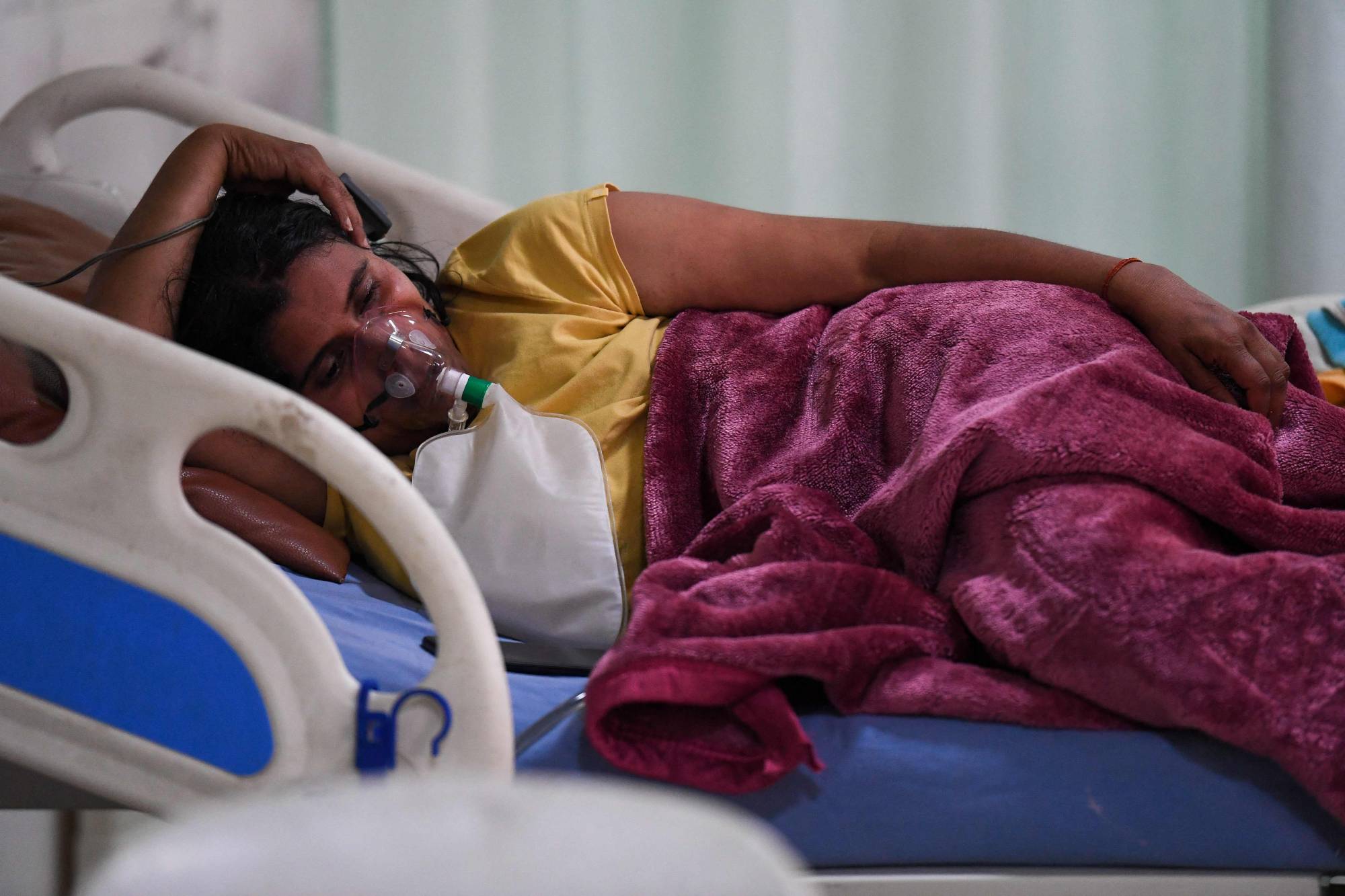 A COVID-19 patient breaths with the help of an oxygen mask inside the intensive care unit of the Teerthanker Mahaveer University hospital in Moradabad, India on Wednesday. | AFP-JIJI