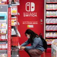 A customer browses the gaming section of Nintendo products at a shop in Tokyo on Thursday. | AFP-JIJI