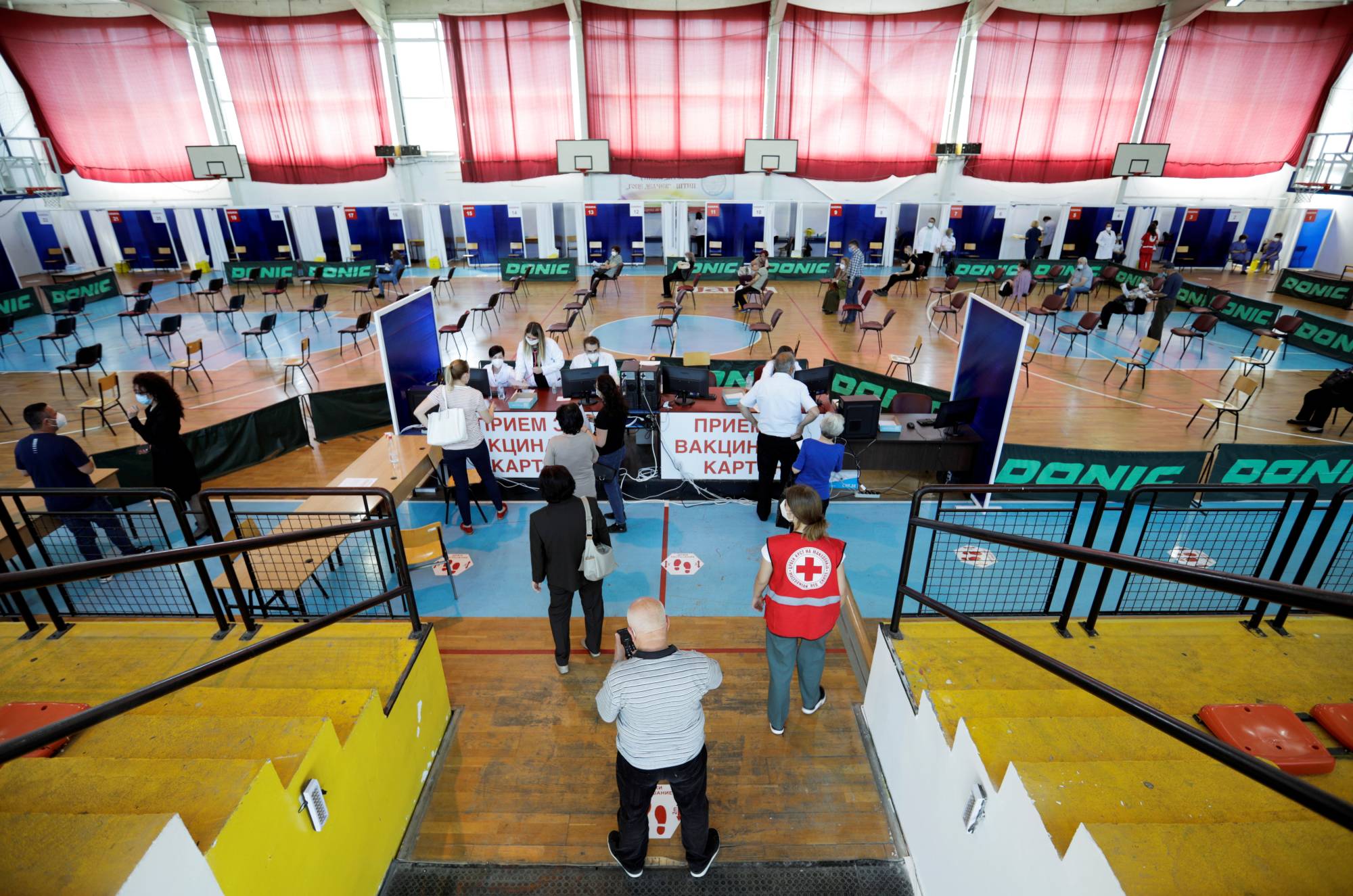 People arrive to receive a dose of China's Sinopharm COVID-19 vaccine at a sports center in Stip, North Macedonia, on Thursday. | REUTERS