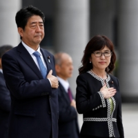Then-Prime Minister Shinzo Abe and Tomomi Inada, the defense minister at the time, review an honor guard before a meeting with senior Self-Defense Force members at the Defense Ministry in Tokyo in September 2016.  | REUTERS