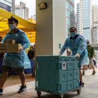 Staff members transport medical materials to a community vaccination center in Hong Kong. | BLOOMBERG 