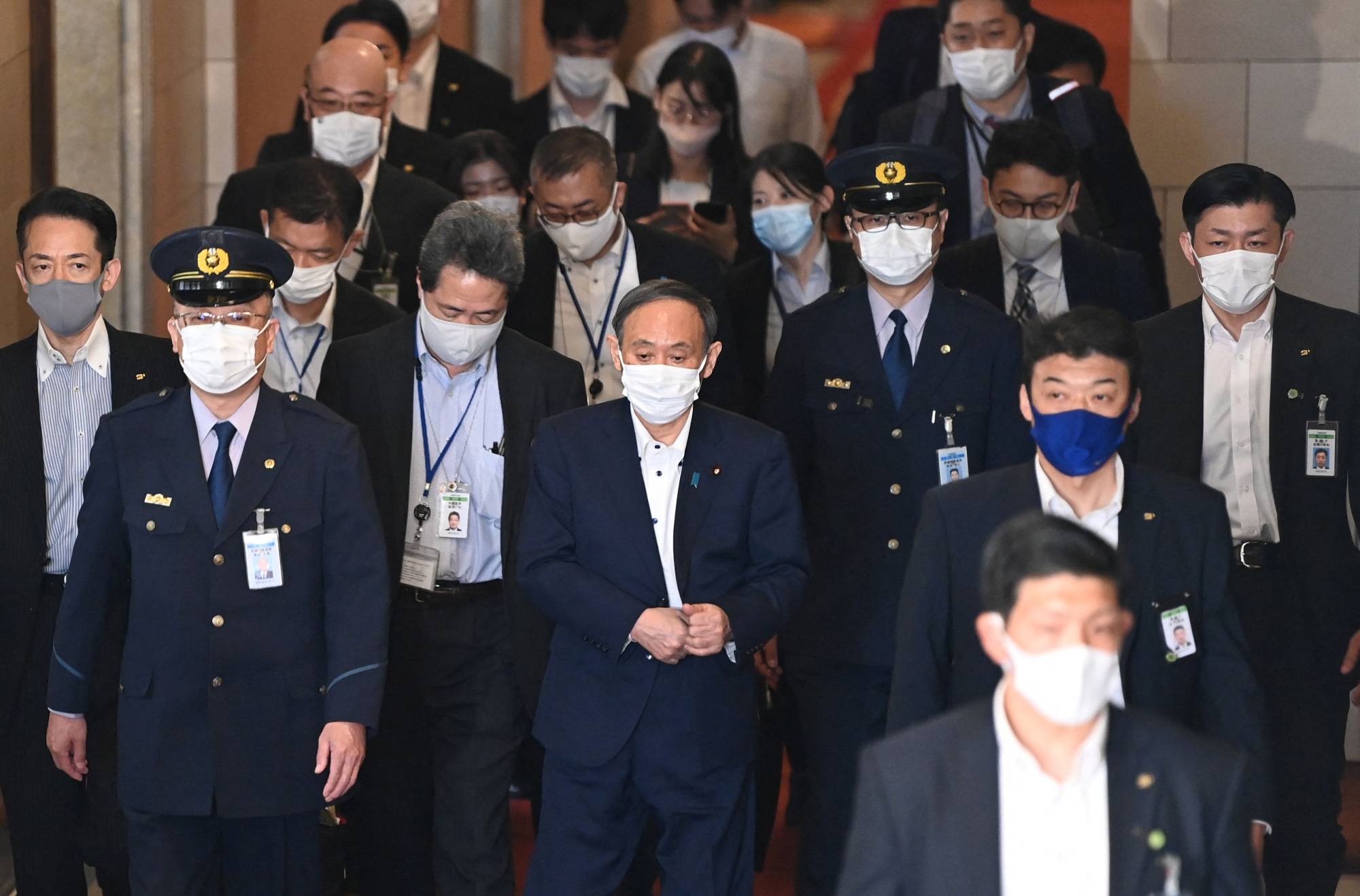 Prime Minister Yoshihide Suga leaves after a parliamentary committee meeting in Tokyo on Monday. | AFP-JIJI