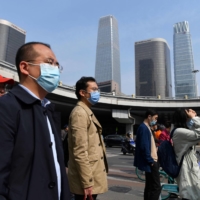 Commuters in Beijing on Tuesday morning. China will need to defy a regional trend, where declining fertility rates have tended to coincide with slow or stagnant economic growth. | AFP-JIJI