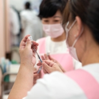 Nurses prepare vaccines from vials for a routine vaccination at Muza Kawasaki Pediatric Clinic in Kawasaki, Kanagawa Prefecture. | ROB GILHOOLY