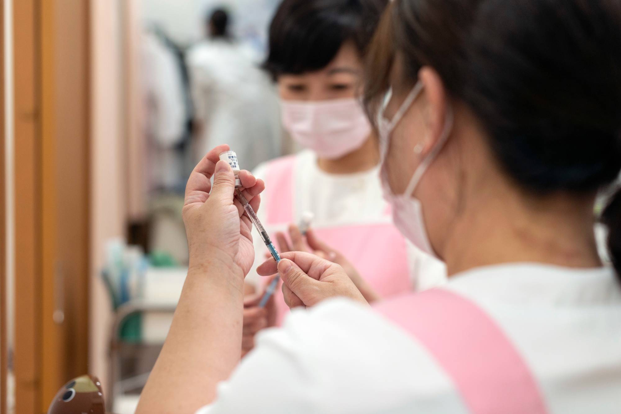 Nurses prepare vaccines from vials for a routine vaccination at Muza Kawasaki Pediatric Clinic in Kawasaki, Kanagawa Prefecture. | ROB GILHOOLY