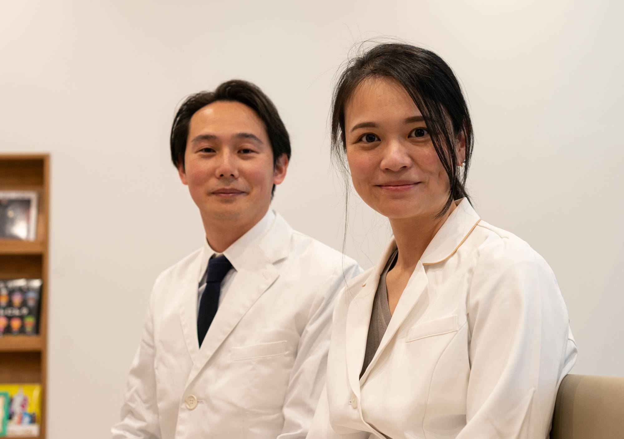 Clinic director Rie Mitsui and her husband, Toshikatsu, sit in the waiting room at Muza Kawasaki Pediatric Clinic in Kawasaki, Kanagawa Prefecture, in May. Toshikatsu, who was formerly a vaccine researcher at Keio University School of Medicine's pediatrics department, joined his wife after she opened the clinic in 2016. | ROB GILHOOLY