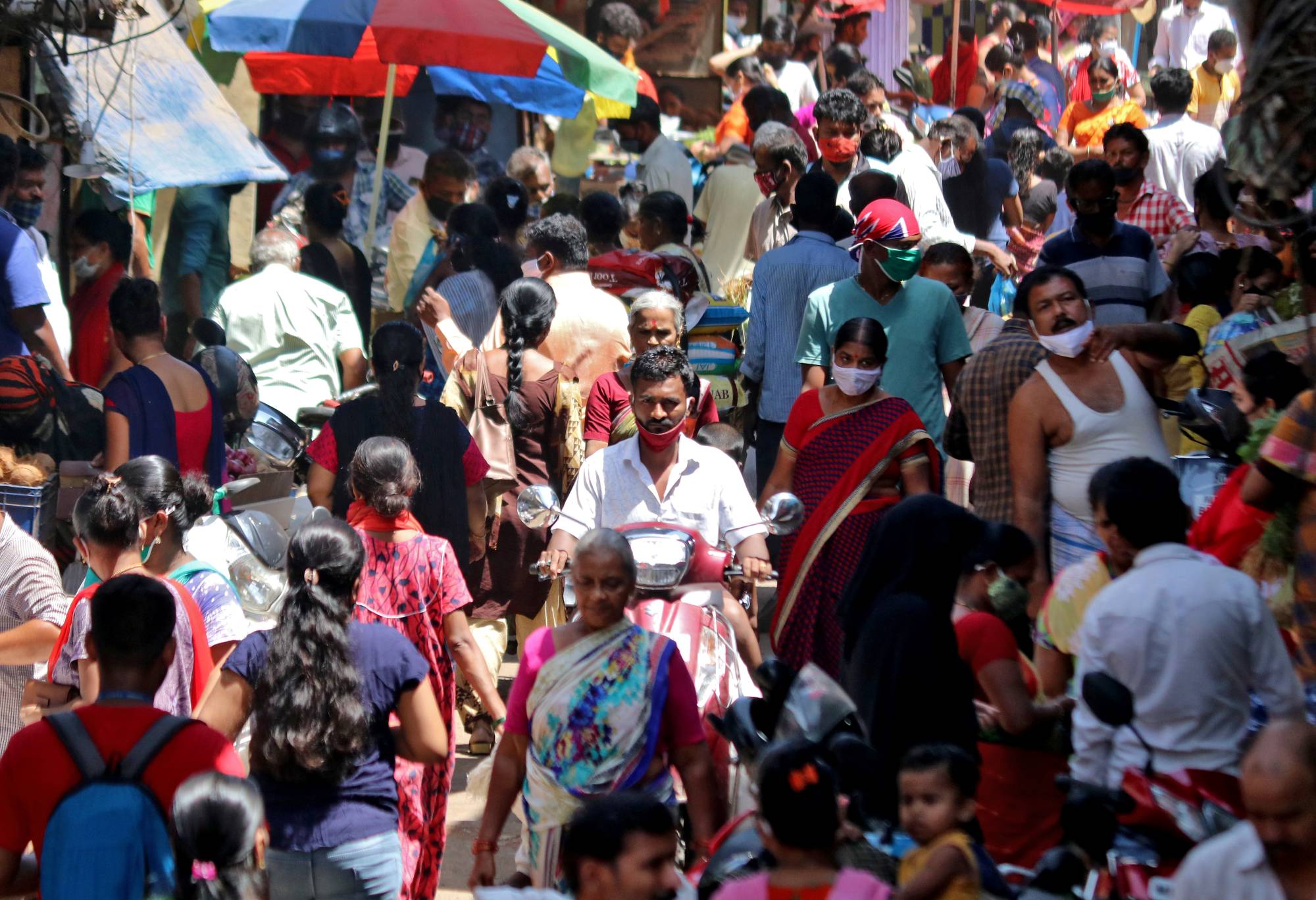 Crowds fill a marketplace in a Mumbai slum in April. | REUTERS