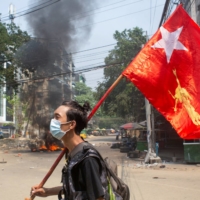 A man holds a National League for Democracy (NLD) flag during a protest against the military coup in Yangon, Myanmar, on March 27. | REUTERS