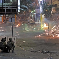 Palestinians clash with Israeli security forces in the center of the West Bank town of Hebron on Wednesday. | AFP-JIJI