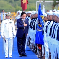 Japan\'s then-state minister of defense, Kenji Wakamiya (center), reviews an honor guard during a transfer ceremony of Japanese training aircraft to the Philippine Navy at a naval facility south of Manila in March 2017.  | REUTERS 