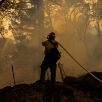A private firefighter monitors a backfire during the Glass Fire in Calistoga, California, in October of last year. | REUTERS