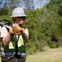 Private firefighter Sean Pafford carries his chainsaw after cutting dead tree limbs as part of a fire prevention project at a park outside Sacramento, California, on April 5.  | REUTERS