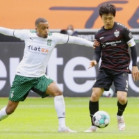 Stuttgart\'s Wataru Endo (right) contends for the ball against a Borussia MG player on Saturday in Monchengladbach, Germany. | KYODO