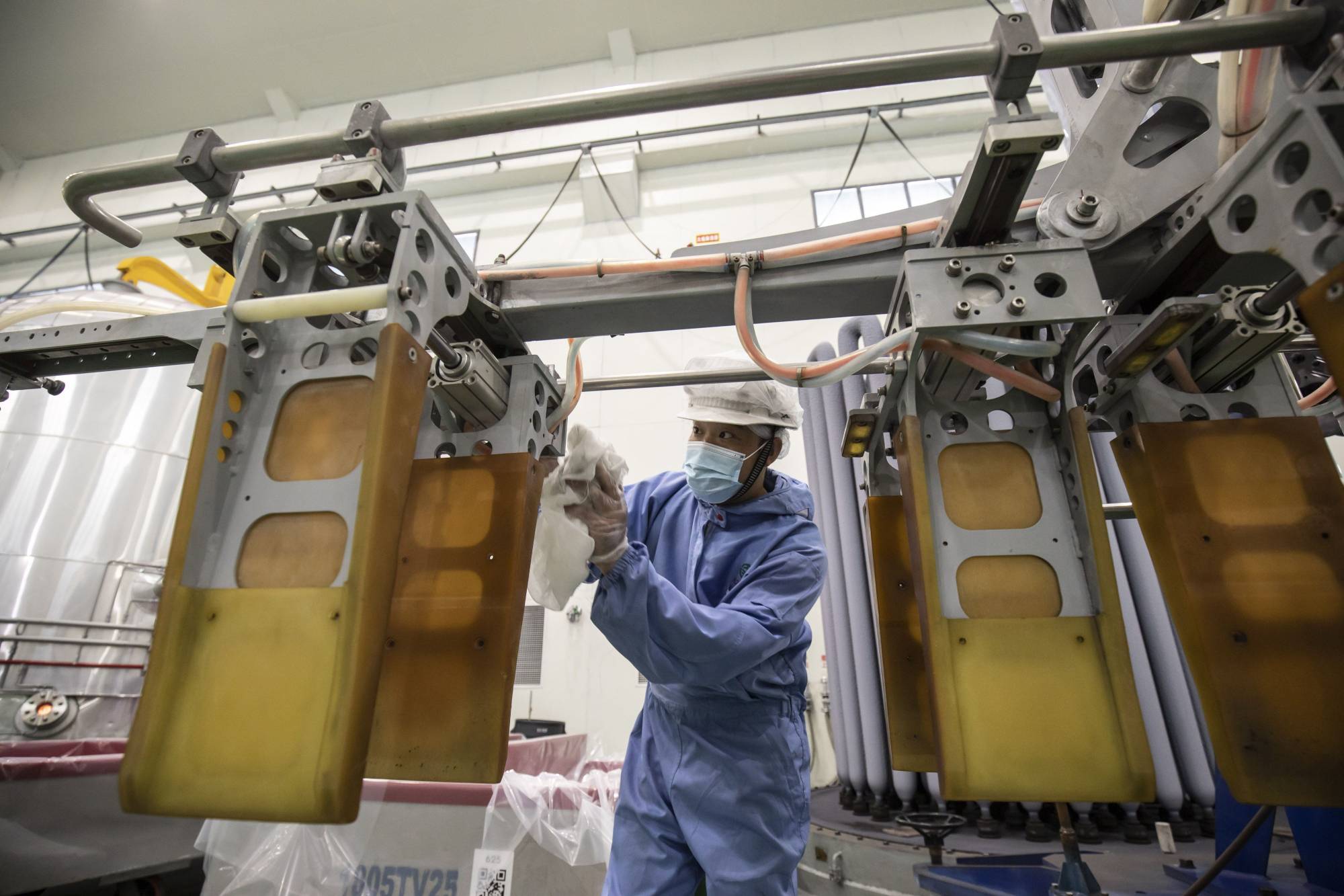 A worker harvests polysilicon rods from chemical vapor deposition chambers at the Daqo factory in Shihezi, Xinjiang, China. | BLOOMBERG 