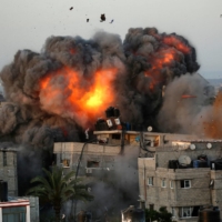 A ball of fire erupts from a building in Gaza City\'s Rimal residential district on Sunday during a massive Israeli bombardment on the Hamas-controlled enclave. | AFP-JIJI