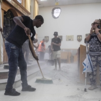 People clean a synagogue in Ashkelon, Israel, damaged by a missile from Gaza on Sunday. | DAN BALILTY / THE NEW YORK TIMES