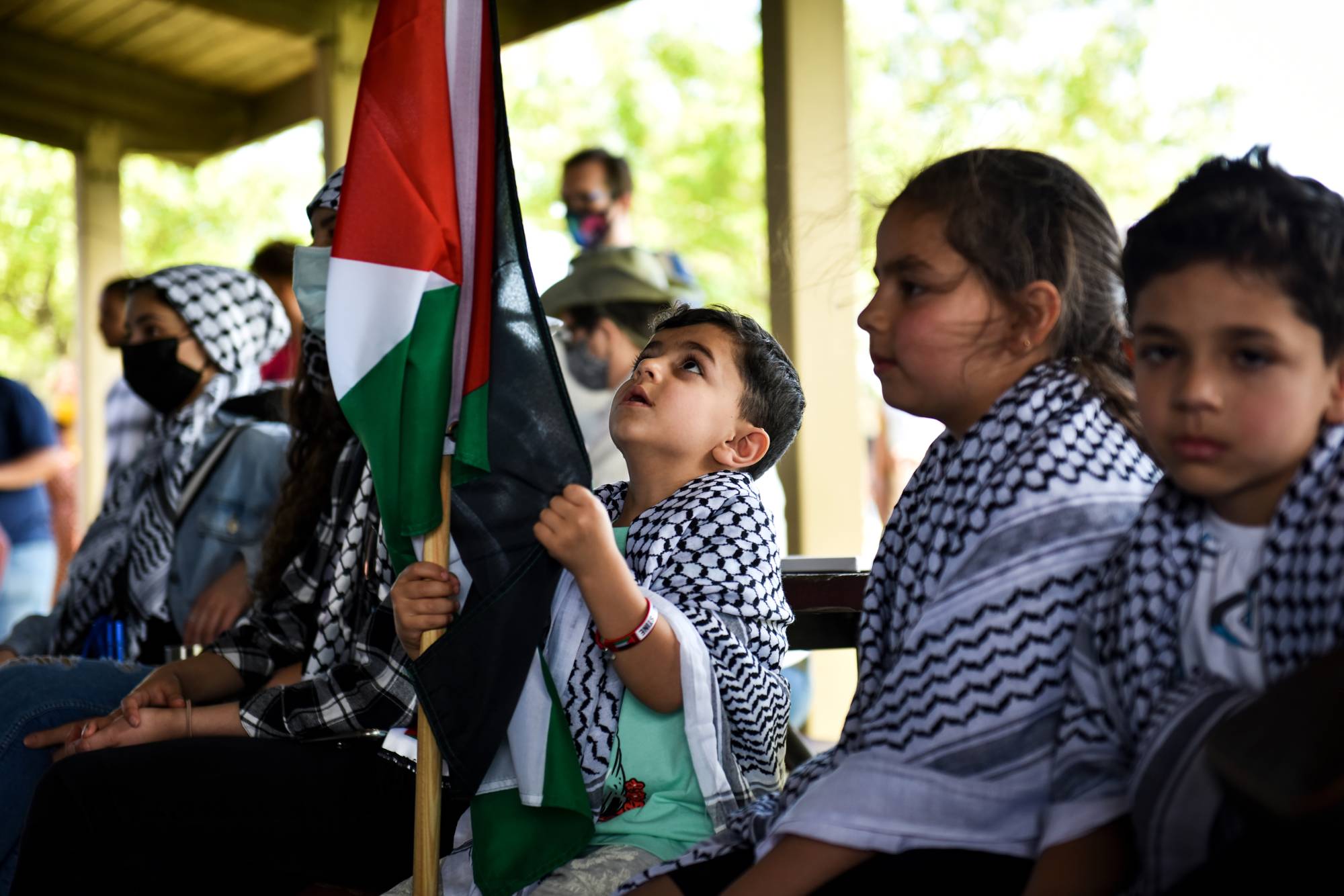 Children sit among people supporting Palestinians during a rally in Dearborn, Michigan, on Tuesday as U.S. President Joe Biden visited a nearby car plant. | Emily Rose Bennett / The New York Times