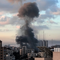 Smoke rises from a building in Gaza City, Gaza Strip, on Tuesday following an Israeli airstrike.  | HOSAM SALEM / THE NEW YORK TIMES