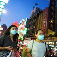 People wearing face masks shop for street food in Chinatown amid the spread of the coronavirus disease (COVID-19) in Bangkok. | REUTERS