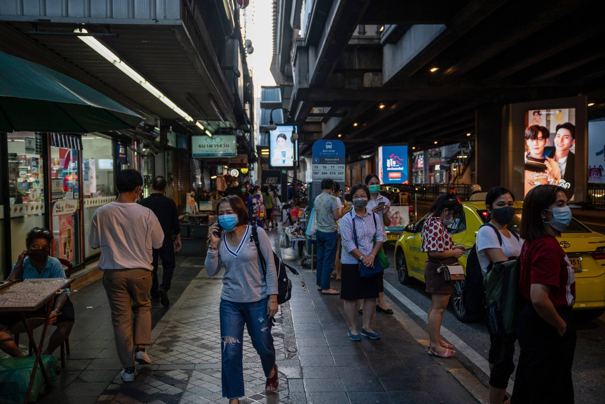 Pedestrians walk along Silom road in Bangkok, Thailand, on Thursday. Foreign travelers who have visited Thailand and six other countries will be subjected to a ban on entry to Japan from Friday. | BLOOMBERG