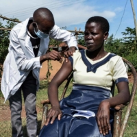 A woman receives a dose of the Oxford-AstraZeneca COVID-19 vaccine in Siaya, Kenya, on Tuesday.  | AFP-JIJI