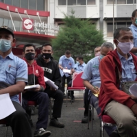 Workers wait to receive COVID-19 vaccines at a plant in Tangerang, Indonesia, on Wednesday. | BLOOMBERG 