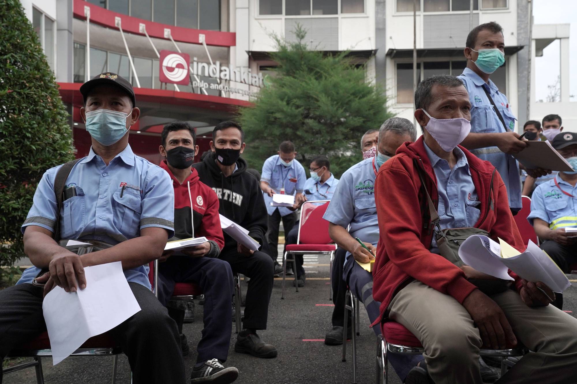 Workers wait to receive COVID-19 vaccines at a plant in Tangerang, Indonesia, on Wednesday. | Bloomberg 