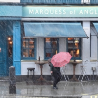 People walk past a reopened pub as COVID-19 restrictions continue to ease in London, on May 18. | REUTERS