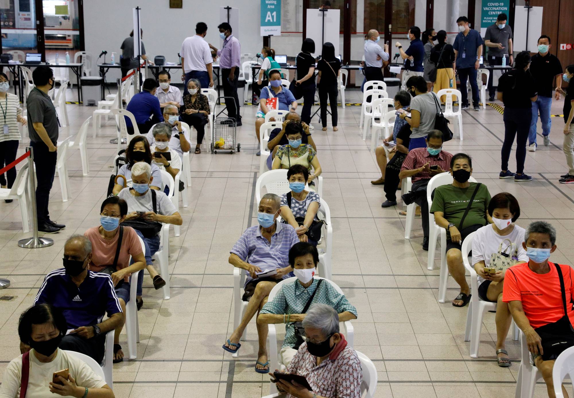 People above 70 years old wait in an observation area after inoculation with a COVID-19 vaccine at a vaccination center in Singapore on Jan. 27. | REUTERS