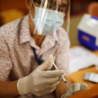 A health care worker administers a COVID-19 vaccine at a hospital in Bangkok on Wednesday. | REUTERS