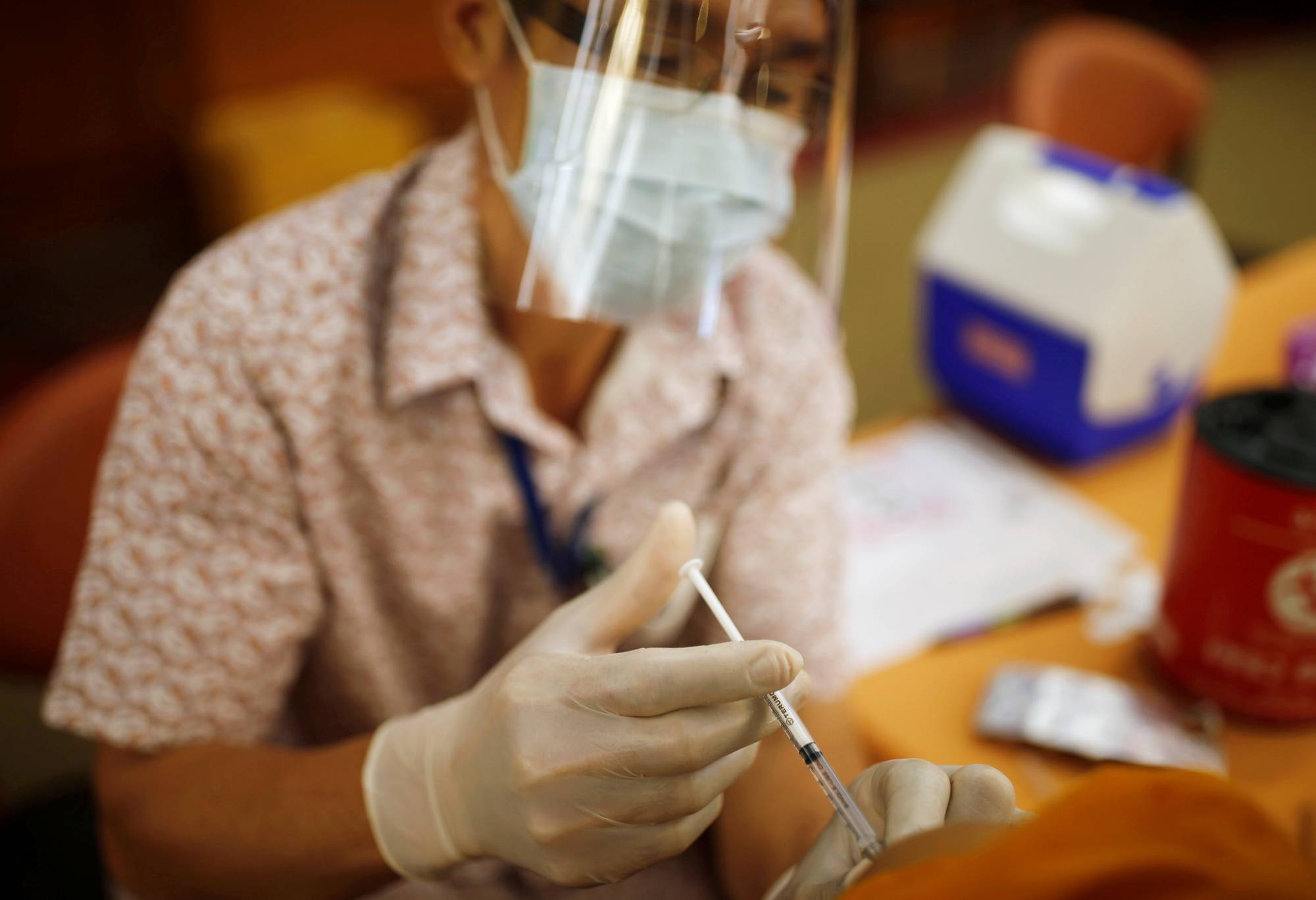 A health care worker administers a COVID-19 vaccine at a hospital in Bangkok on Wednesday. | REUTERS
