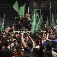 Palestinians celebrate in the streets following a ceasefire brokered by Egypt between Israel and the ruling Islamist movement Hamas in the Gaza Strip, on Friday in Gaza City. | AFP-JIJI