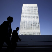 Pedestrians walk past the Hamamatsucho Building, home to Toshiba Corp.\'s headquarters, in Tokyo in April. | BLOOMBERG
