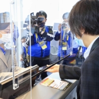 A passenger checks in at Haneda Airport on Monday using the International Air Transport Association Travel Pass. | KYODO