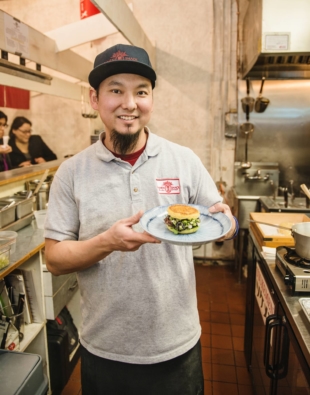 Keizo Shimamoto holding a ramen burger, which he debuted in Brooklyn in 2013 to massive fanfare. | COURTESY OF KEIZO SHIMAMOTO 