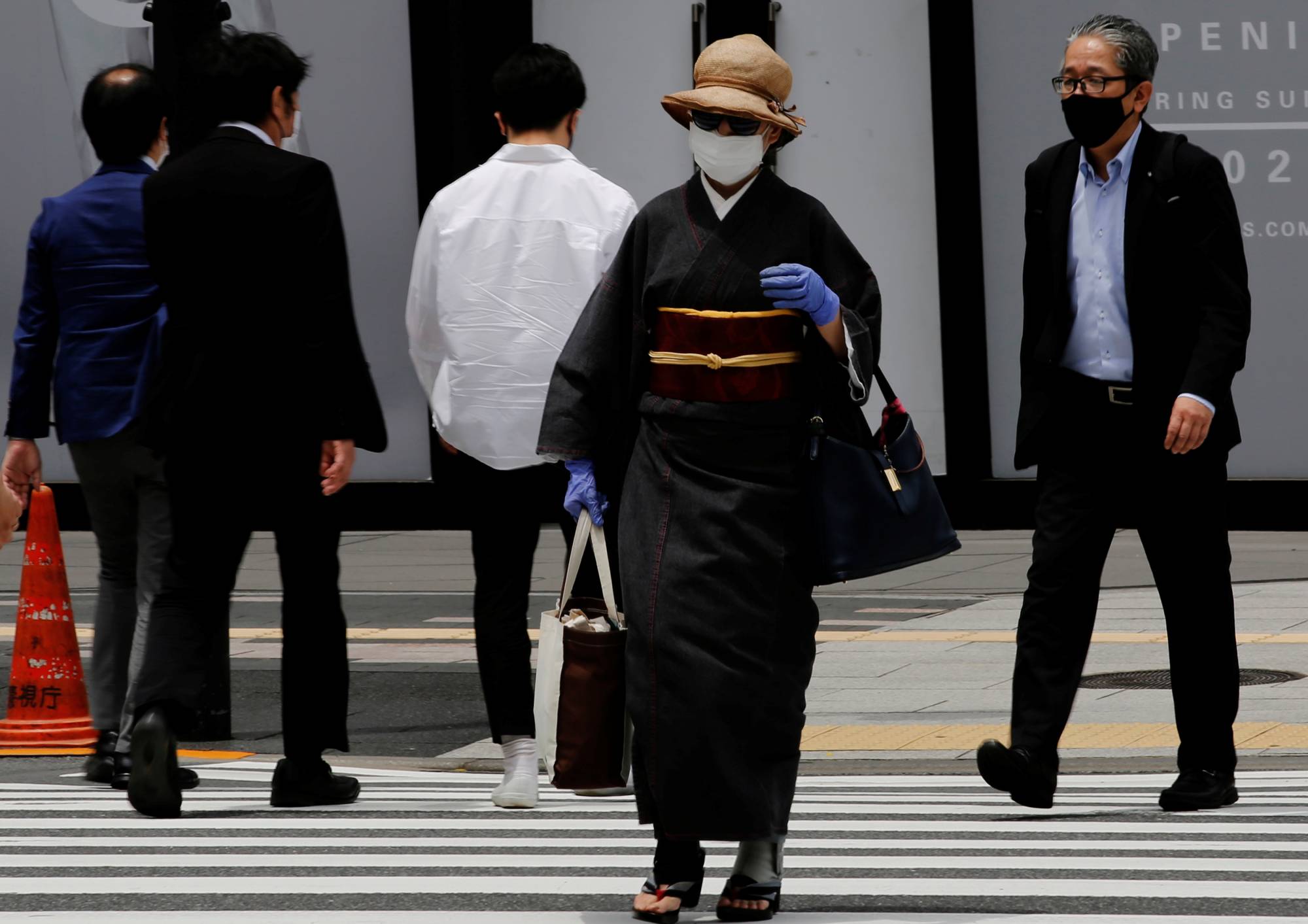 A woman walks through a shopping district in Tokyo on Friday. | REUTERS