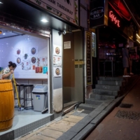 A worker cleans up at a restaurant in the Lan Kwai Fong nightlife area in Hong Kong on April 29. | BLOOMBERG 