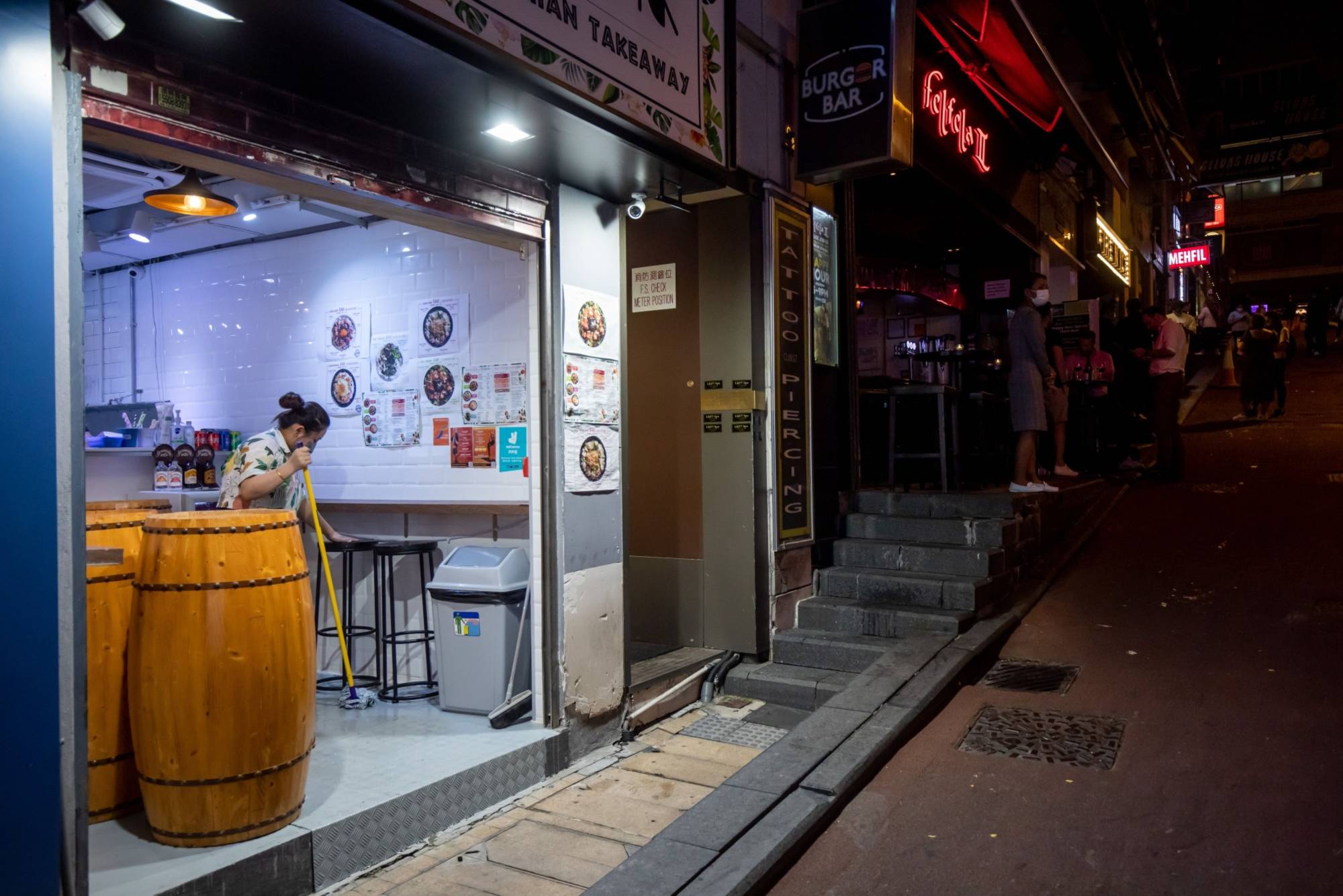 A worker cleans up at a restaurant in the Lan Kwai Fong nightlife area in Hong Kong on April 29. | Bloomberg 