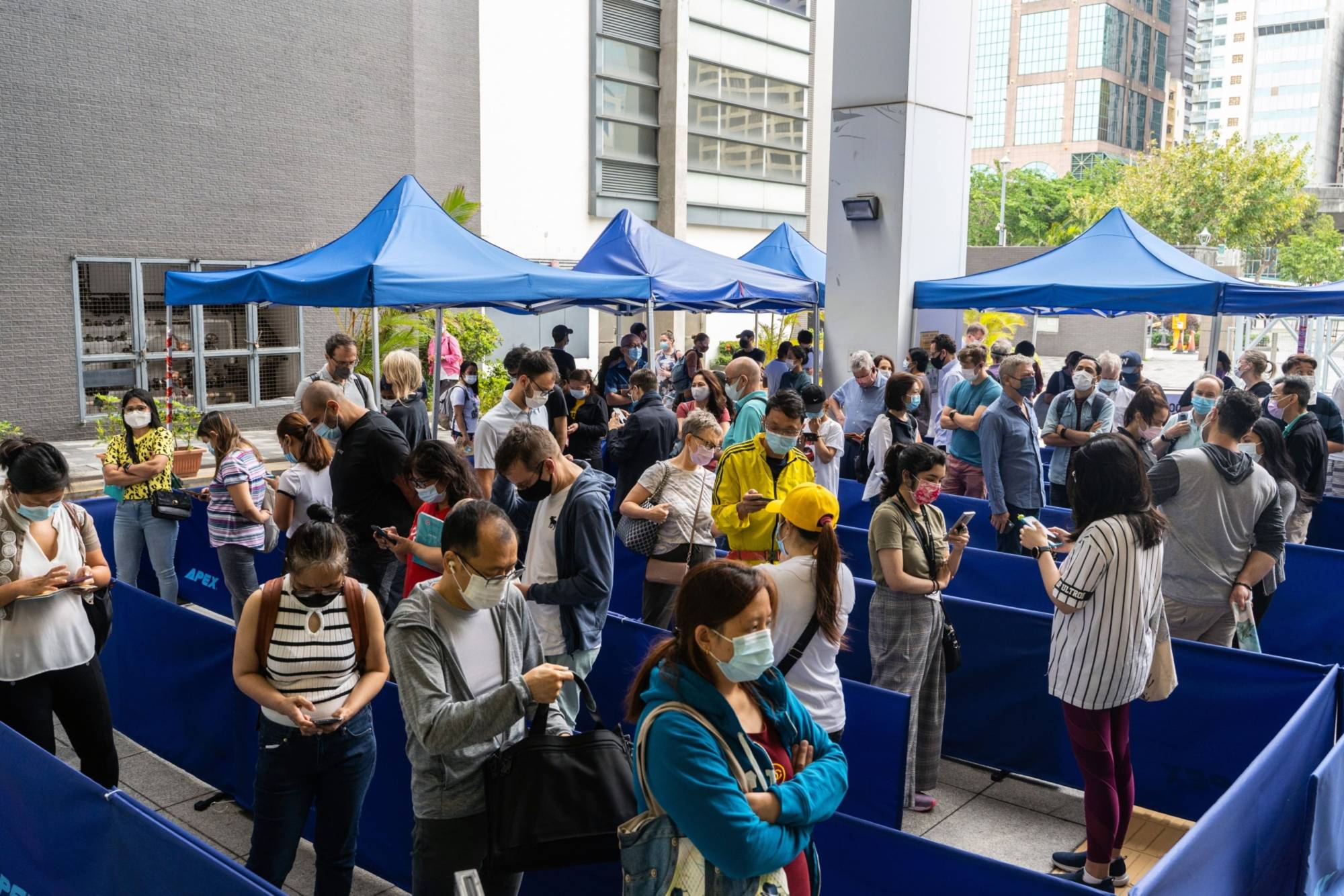 People line up outside a community vaccination center in Hong Kong on April 26. | Bloomberg 