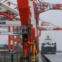 A cargo ship berths at the international cargo terminal at the port of Tokyo. Japanese companies cut spending on plants and equipment for the fourth consecutive quarter in January-March. | AFP-JIJI