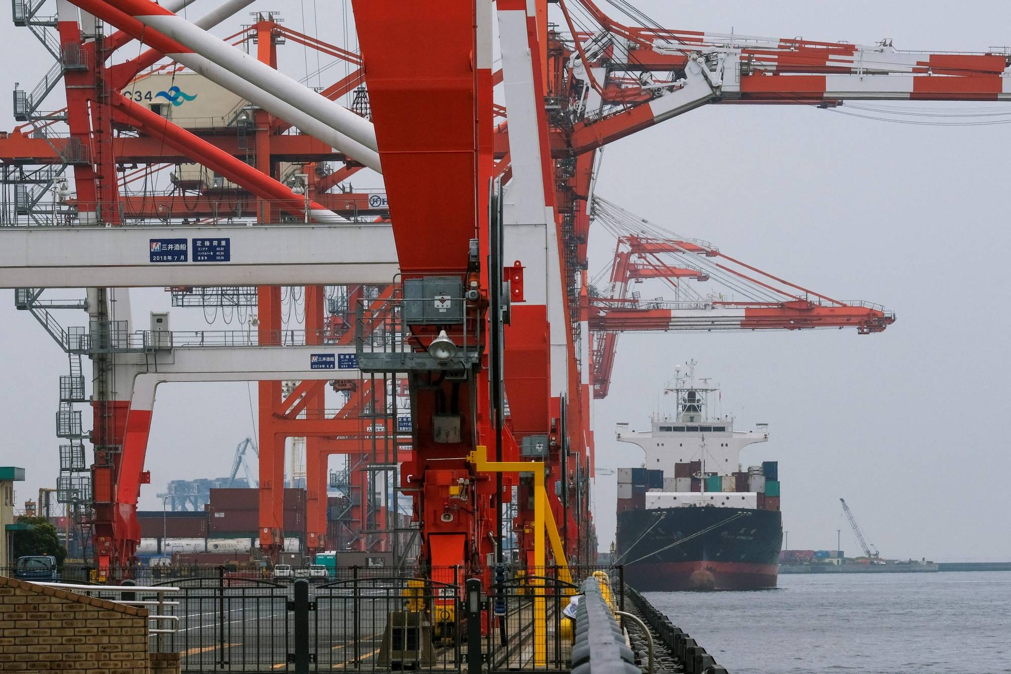 A cargo ship berths at the international cargo terminal at the port of Tokyo. Japanese companies cut spending on plants and equipment for the fourth consecutive quarter in January-March. | AFP-JIJI