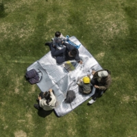 People picnic at a river-side park in Shanghai, China, on April 10. China\'s population is aging more quickly than most of the worlds developed economies due to decades of family planning aimed at halting population growth.  | BLOOMBERG 